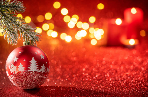 istock Red bauble with fir tree drawing and Christmas lights on glowing 1431726918