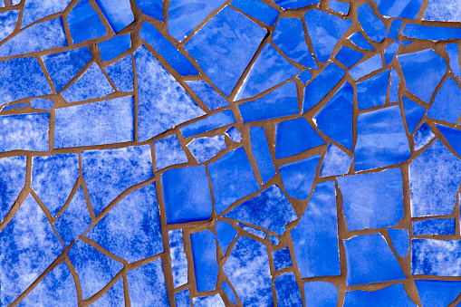 Broken dark  blue tiles  pattern, wall or flooring decoration . Traditional trencadis decoration, construction,  full frame abstract view. Spain.