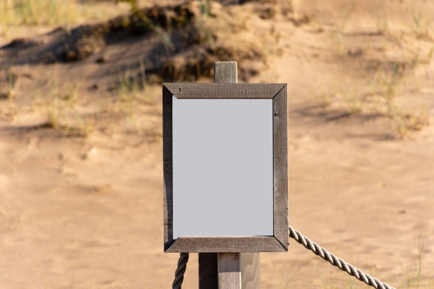 istock Empty white sign with partly broken wooden frame on a sandy beach 1431729661