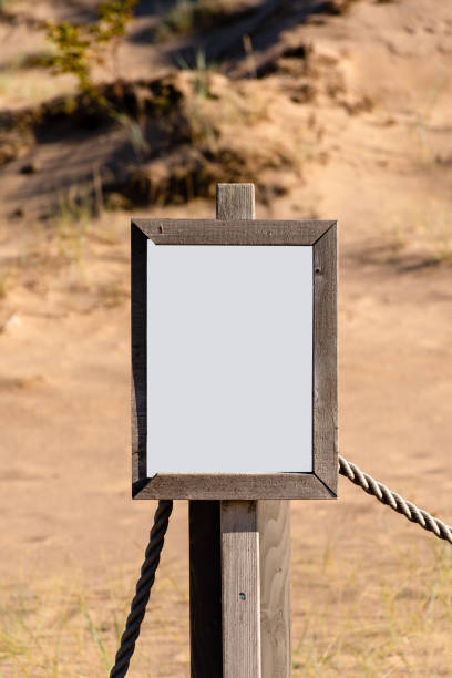 istock Empty white sign with partly broken wooden frame on a sandy beach 1431729938