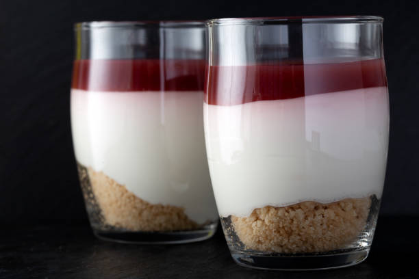 Sweet raspberry dessert in glass over dark slate - close up view