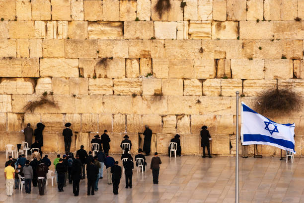 jüdische gläubige beten an der klagemauer in jerusalem - israel judaism israeli flag flag stock-fotos und bilder