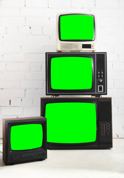 istock Four vintage green screen televisions with a white brick background. 1431735043