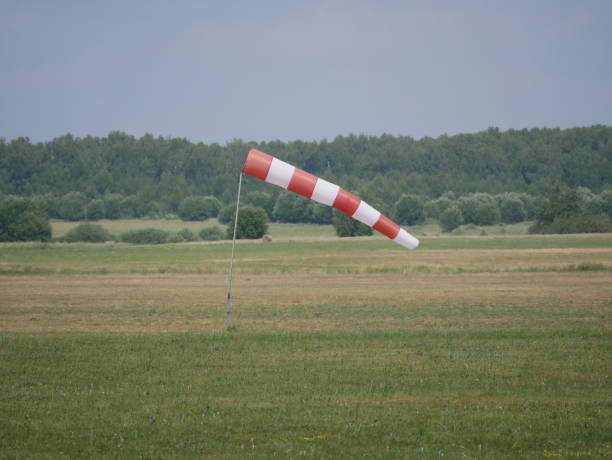 istock Wind direction and strength indicator on the airfield on a sunny summer day. Synthetic product made of red and white fabric. 1431735385