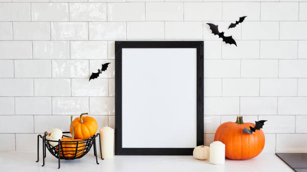 istock Vertical black picture frame mockup with pumpkins and halloween home decor on white desk table in scandinavian kitchen interior. Halloween holiday poster design. 1431736705