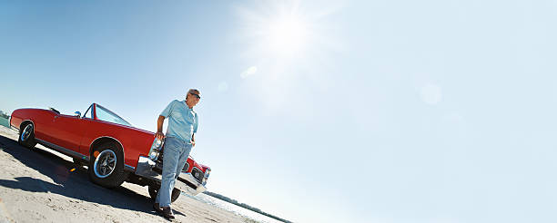 istock Senior with classic convertible car 143174106