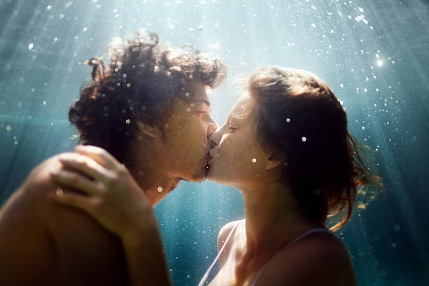 feliz pareja submarino - besando fotografías e imágenes de stock