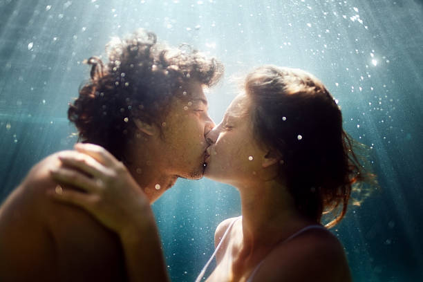 feliz casal debaixo de água - beijar imagens e fotografias de stock