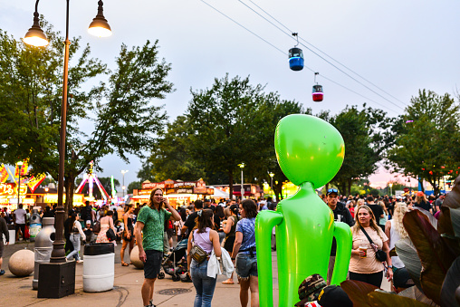 08/27/2022 - Falcon Heights, Minnesota, USA: Minnesota State Fair Crowd of People and Alien at Sunset