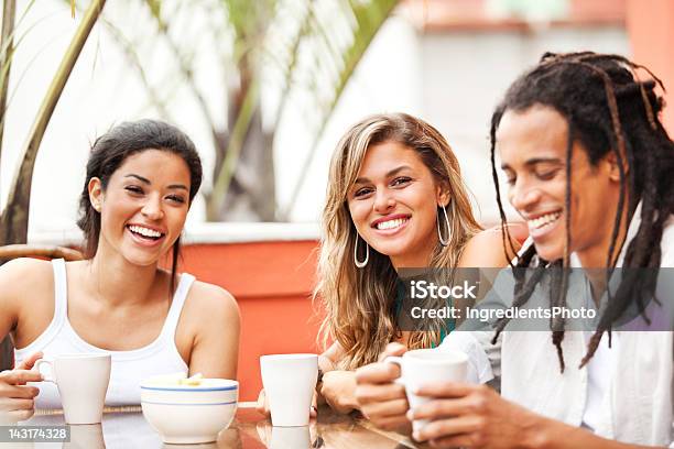 Tres Jóvenes Y Alegres Amigos Mientras Disfruta De La Compañía De Sus En Café Foto de stock y más banco de imágenes de Amistad
