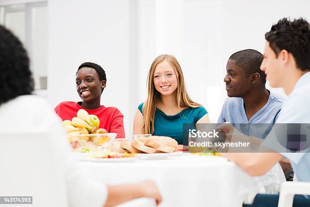 Grupo De Amigos Cenando Juntos Foto de stock y más banco de imágenes de Adolescente - Adolescente, Adulto joven, Cena con amigos