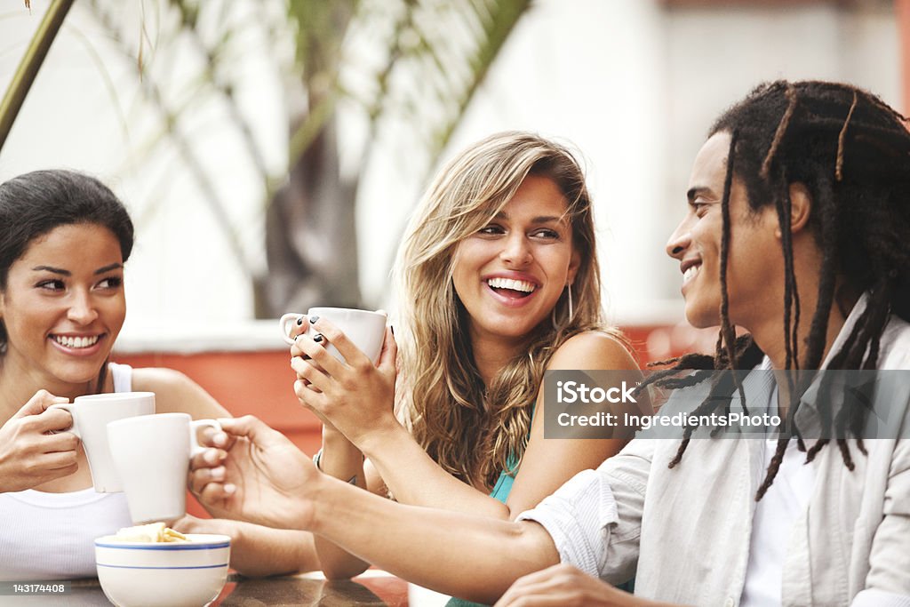 Three cheerful young friends enjoying each other's company in cafe. Three cheerful young friends enjoying each other's company in cafe. Happy and positive emotions. Brazil Stock Photo Three cheerful young friends enjoying each other's company in cafe. Three cheerful young friends enjoying each other's company in cafe. Happy and positive emotions. Brazil Stock Photo