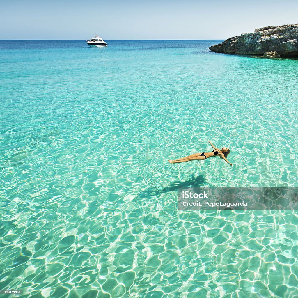 Idyllic holidays Idyllic holidays: girl floating in fresh clean turquoise water. Beach Stock Photo
