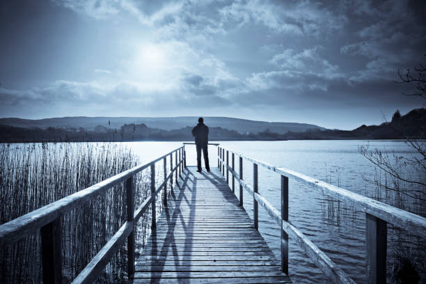 Blue toned image of a man relaxing in the lake.