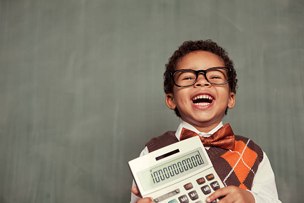 Young Nerd Boy Wearing Glasses Holding Calculator This little accountant just hit the jackpot and earned ten billion dollars for his company. Plenty of room for copy. bow tie photos stock pictures, royalty-free photos & images