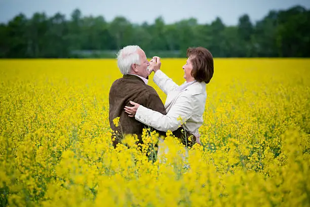 Initial Rating 5/5: Senior couple dancing in blooming canola field.