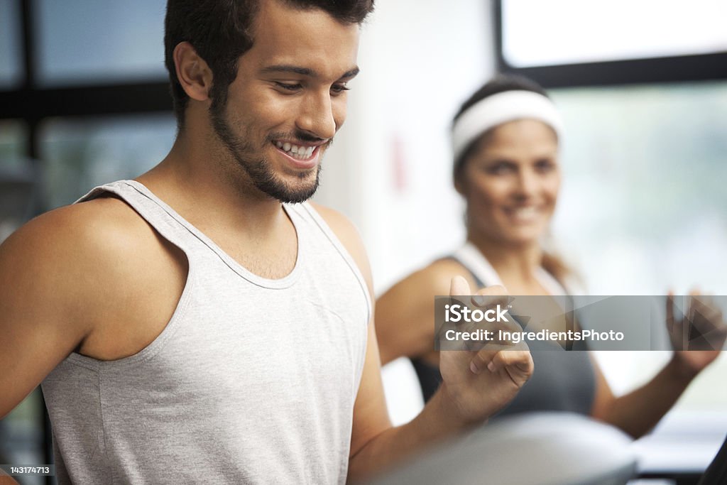 Giovane e bella sorridente persone in esecuzione presso il fitness club - Foto stock royalty-free di Centro benessere - Struttura ricreativa