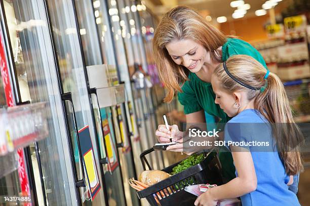 Madre E Hija Verificar Lista De Compras En El Supermercado Foto de stock y más banco de imágenes de Cupón