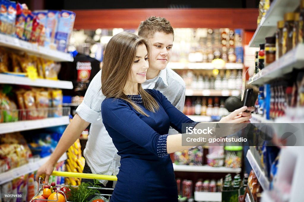 Jeune homme et une femme dans un supermarché - Photo de Confiserie - Mets sucré libre de droits