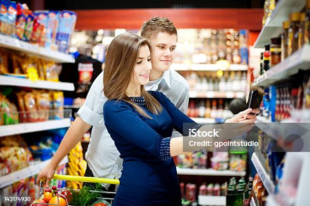 Photo libre de droit de Jeune Homme Et Une Femme Dans Un Supermarché banque d'images et plus d'images libres de droit de Confiserie - Mets sucré - Confiserie - Mets sucré, Faire les courses, Marché - Établissement commercial