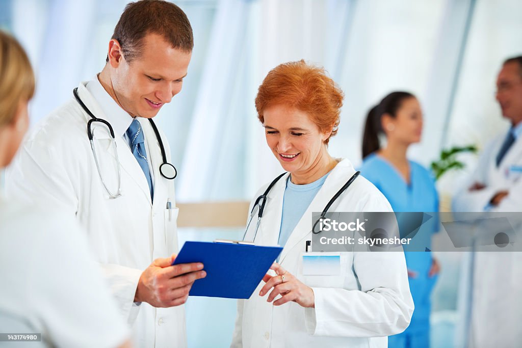 Dos médicos Analizar los informes médicos. - Foto de stock de Adulto libre de derechos