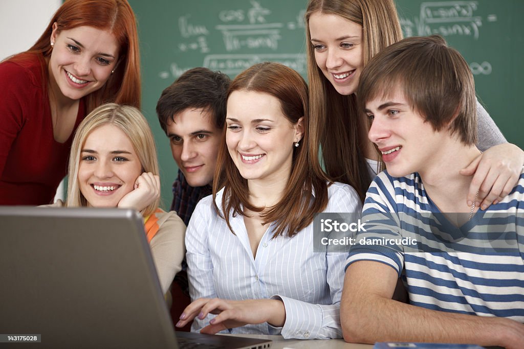 Gruppo di studenti universitari, utilizzando computer portatile in aula - Foto stock royalty-free di Adolescente