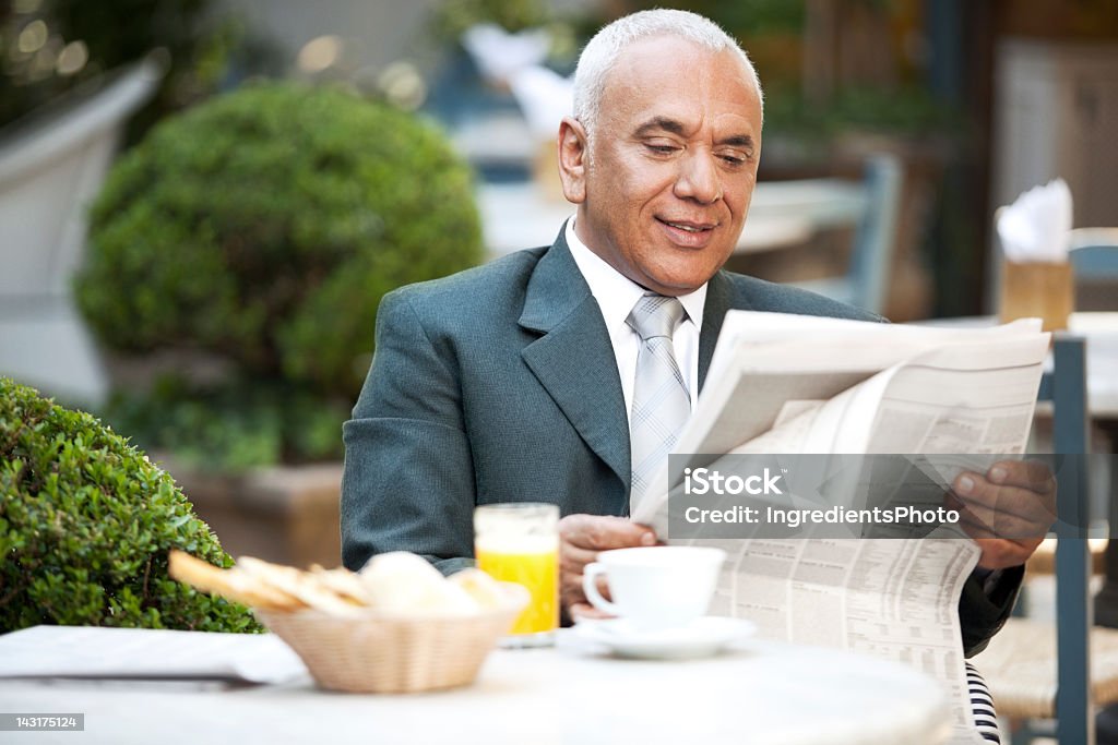 Homme d'affaires Mature heureuse de profiter de son petit déjeuner le matin et des journaux. - Photo de Journal libre de droits