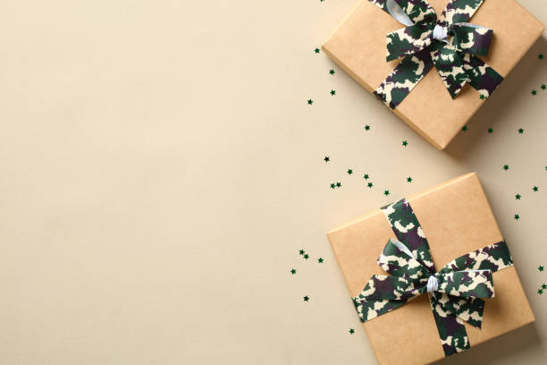 istock Gift boxes with camouflage military ribbon bow on beige background. USA Veterans Day greeting card template. 1431753652