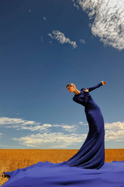 lady in blue dress contra el cielo retrato - alta costura fotos fotografías e imágenes de stock