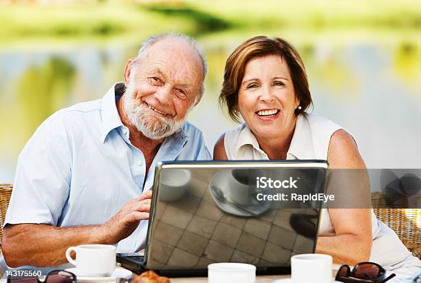 Lächelnd Älteres Paar Teilen Einen Laptop Am Lakeside Terrace Stockfoto und mehr Bilder von 60-69 Jahre