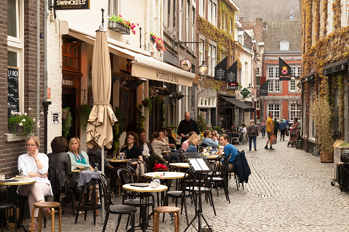 Maastricht, Netherlands, April 13, 2022; Cozy small street with terraces and restaurants in the center of the historic city of Maastricht.