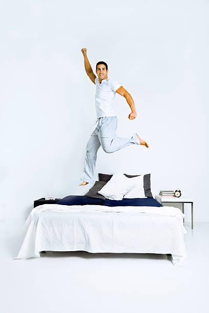 istock Healthy man jumping on bed 143175611