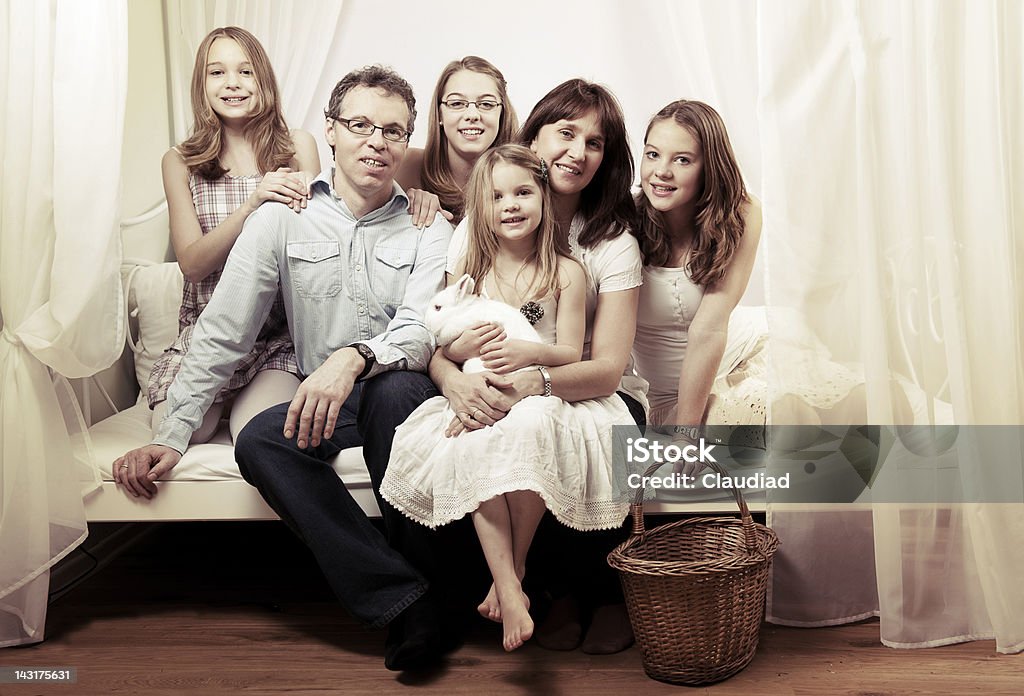 Happy family sitting on bed  Bed - Furniture Stock Photo