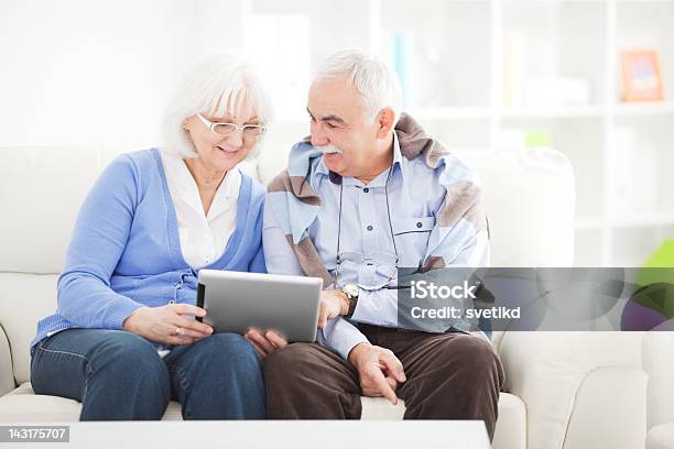Coppia Senior Con Un Tablet - Fotografie stock e altre immagini di 60-64 anni - 60-64 anni, 60-69 anni, Abbigliamento casual