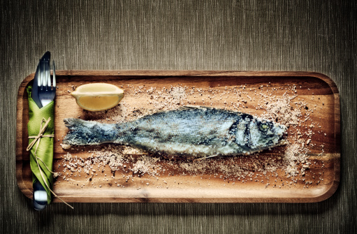 Sea bass on a wooden plate