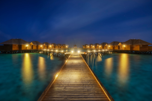 overwater bungalows boardwalk on Maldives at night