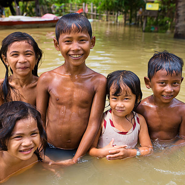 istock Children having fun in the water during flood, Cambodia 143175900