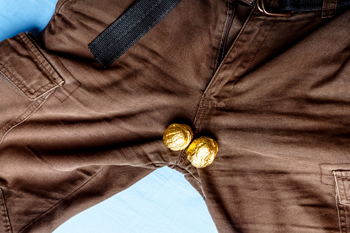 The concept of muscularity. Men's pants with two gold nuts