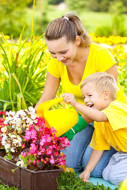 madre e figlio lavorando in giardino - formal garden ornamental garden child single flower foto e immagini stock