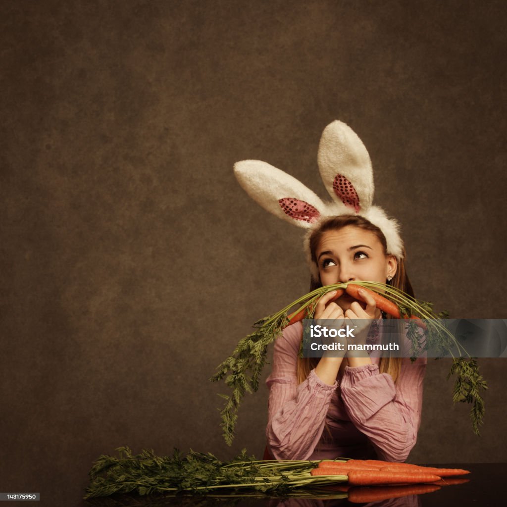 bunny girl with carrot mustache bunny girl making fun with carrot mustache Carrot Stock Photo