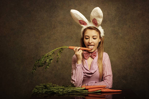 bunny girl lecken a carrot-englische redewendung - easter easter bunny fun humor stock-fotos und bilder