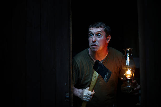 Crazy man with hatchet in wood cabin at night