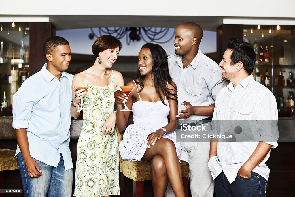 Grupo mixto de Sonriente joven adultos bebiendo cócteles en el bar - Foto de stock de Cóctel - Bebida alcohólica libre de derechos