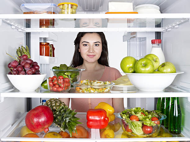 istock Looking from inside of a fridge to a young woman 143176136