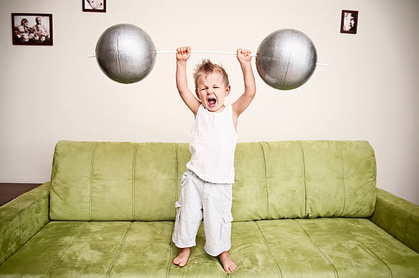 Strong boy Little boy holding heavy weight. lift weights stock pictures, royalty-free photos & images