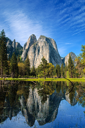 Springtime view of pond in Yosemite valley, with reflection of Cathedral Rocks and Cathedral Spires in water.