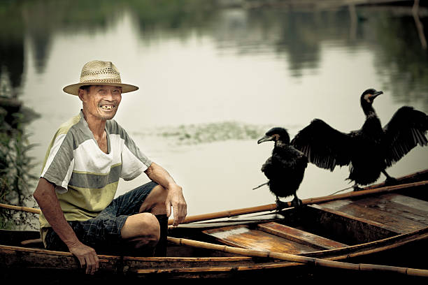 Fishermen fishing on a river wiht cormorant.China's countryside has been fishing this way, but over time, this approach has become increasingly rare, or even disappear.adobe rgb 1998 use.