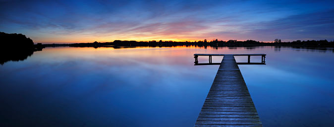Calm Lake with Boardwalk Dock at sunset