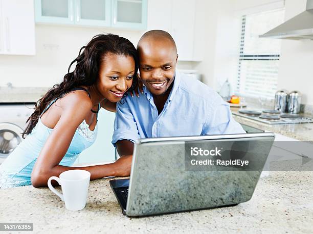 Heads Together A Young Couple Share Laptop At Home Stock Photo - Download Image Now - 20-29 Years, Adults Only, Affectionate