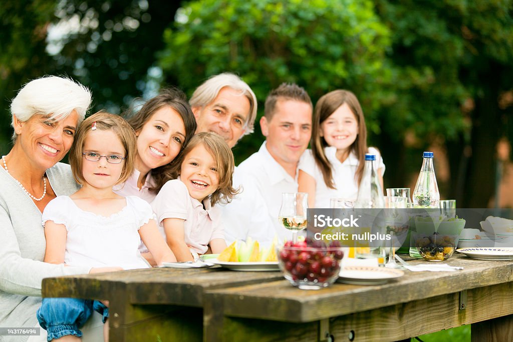 Grande famille ayant un pique-nique dans le jardin - Photo de Adulte libre de droits